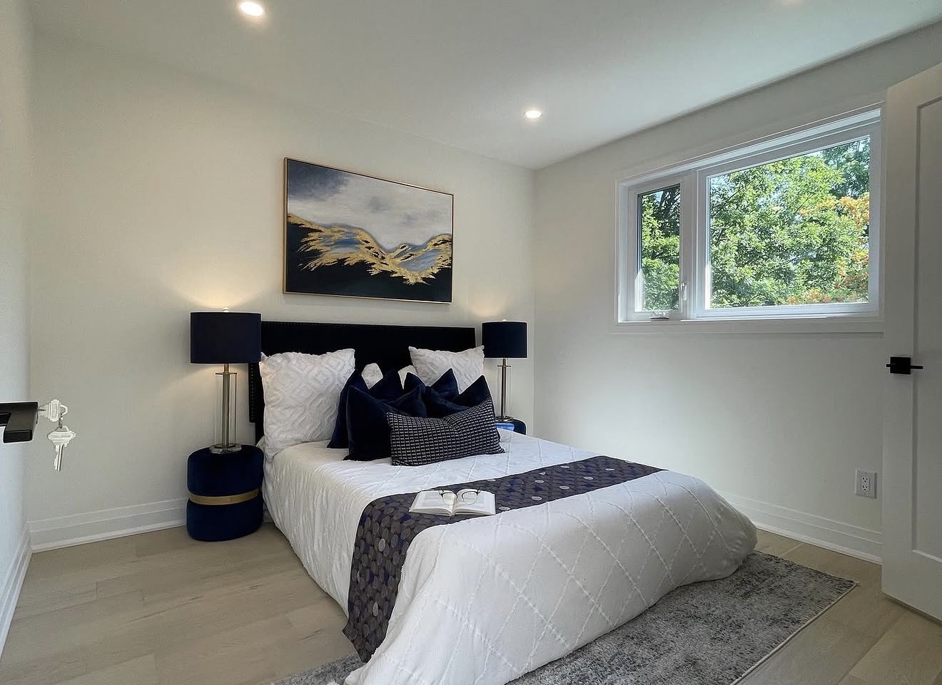 Renovated bedroom with navy accents and white oak flooring