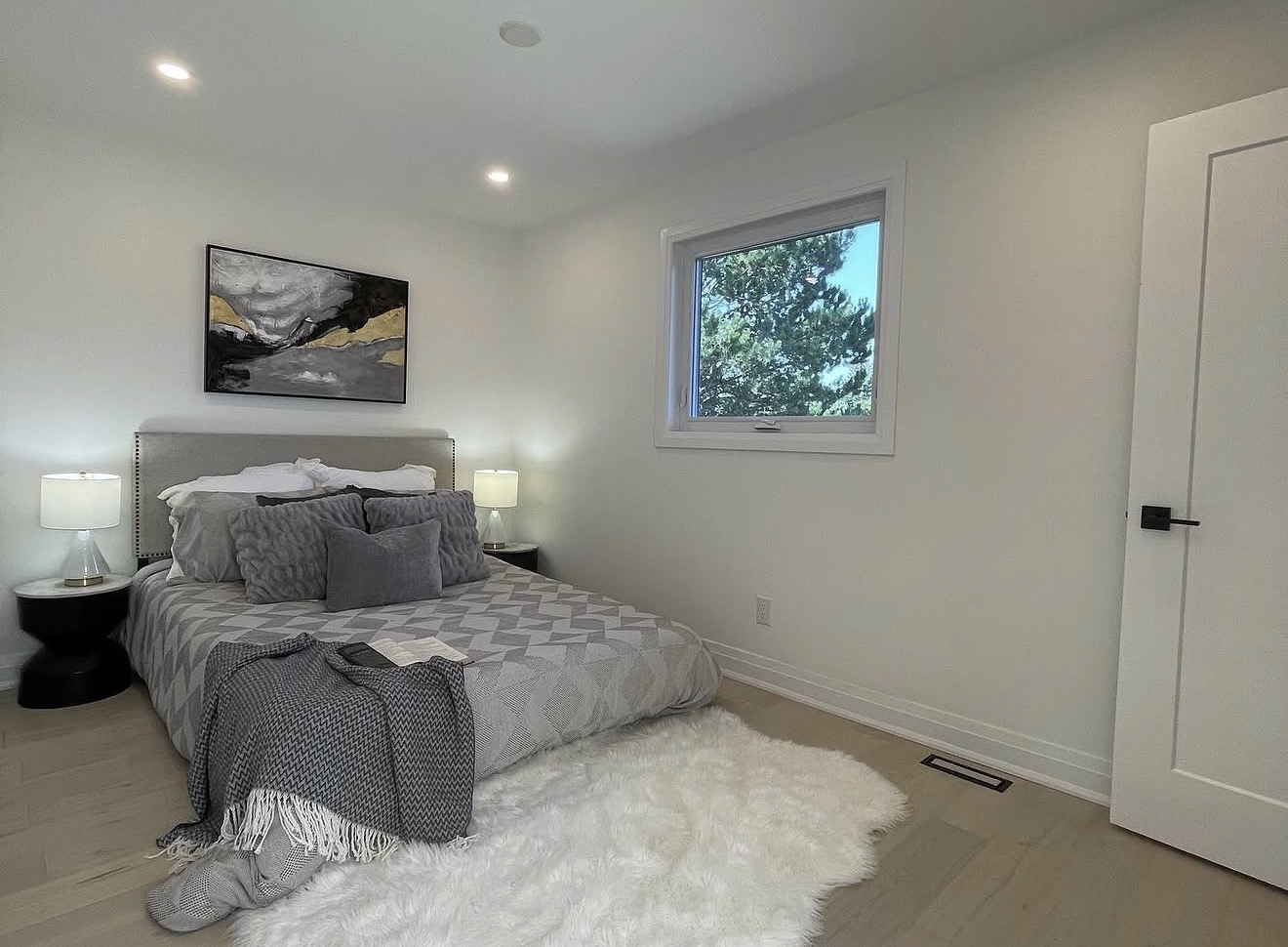 Renovated guest bedroom in soft grey with light hardwood floors
