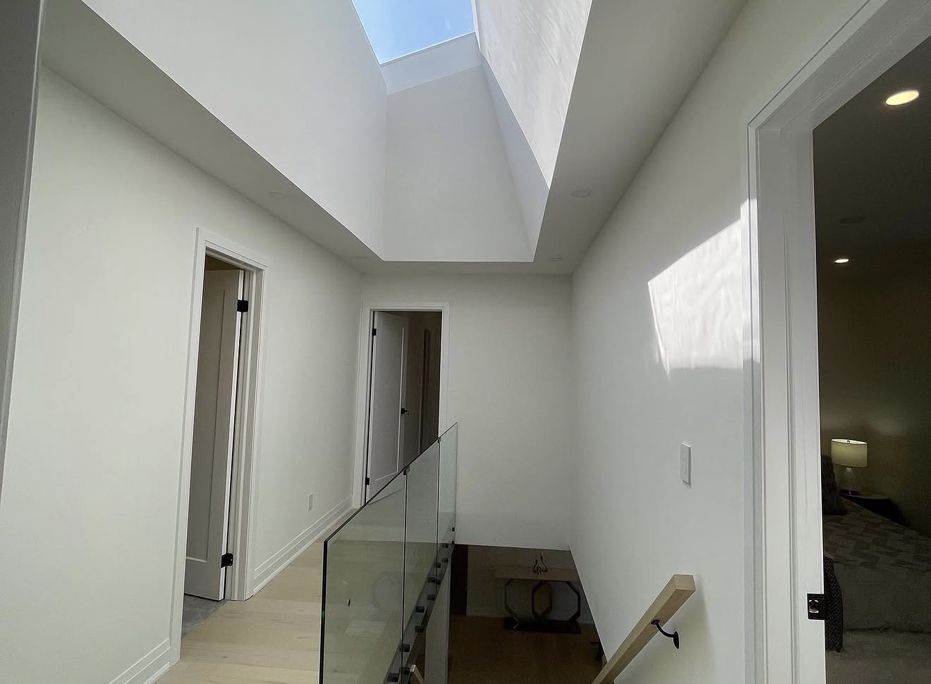 Bright upper hallway with skylight, crisp painted walls and clean trim