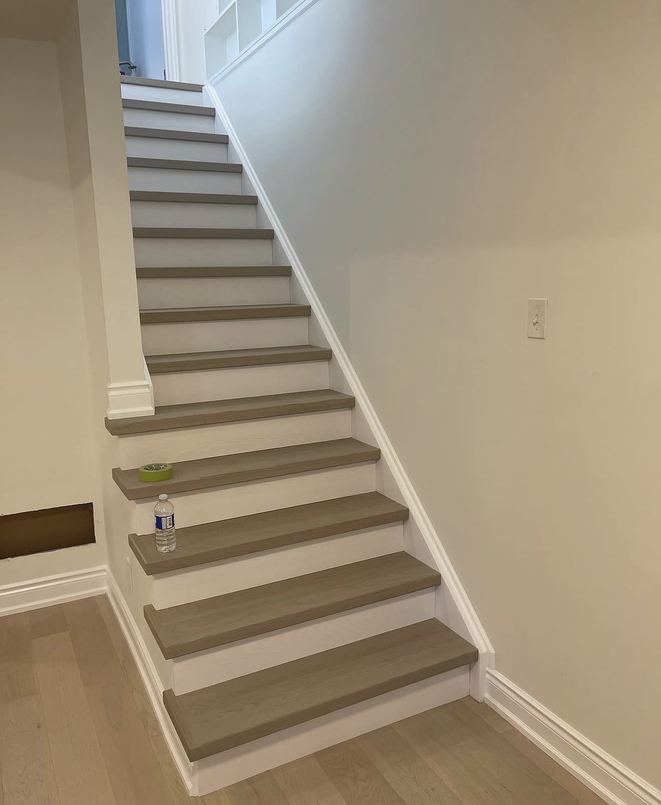 The same staircase after renovation with oak treads, white risers and clean trim